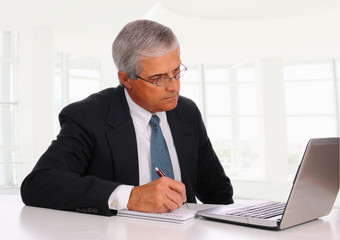 Middle Age Businessman at desk with Laptop