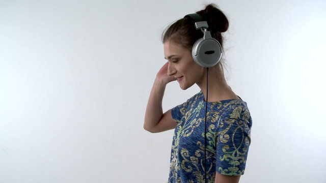 A head and shoulders shot of a Girl with headphones while dancing more to the music
