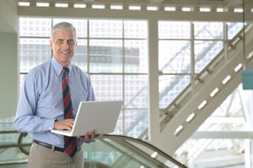 Fototapeta premium Middle aged Businessman with White laptop