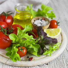 ingredients for fresh vegetable salad - tomatoes, garden herbs and olive oil