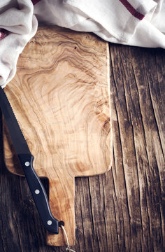 Wooden cooking board and knife close up. Toned image. Top view