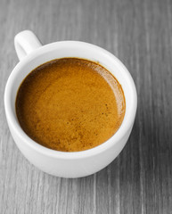 Cup of hot espresso coffee on wooden texture