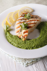 Grilled chicken and mint pea puree close-up on a plate. vertical