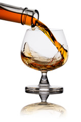 Pouring whiskey in glass isolated on white