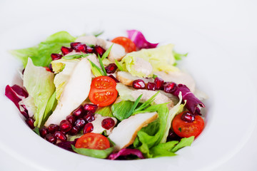 salad with chicken, iceberg lettuce, pomegranate closeup 
