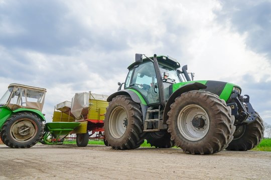 Vorratsbeh&auml;lter mit Minerald&uuml;nger, Traktor mit D&uuml;ngerstreuer
