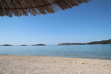 Fototapeta na wymiar Solaris / Schöner kroatischer Strand mit Sonnenbetten