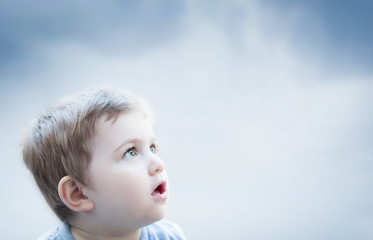 Boy looking at the sky with surprised expression. Child imagination