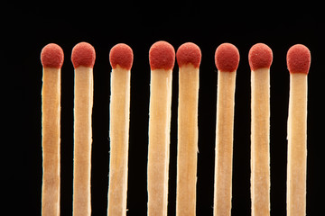Set of eight red wooden matches isolated on black background