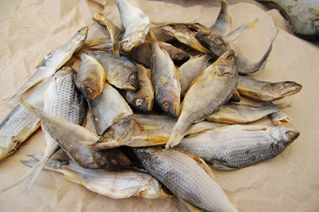 Salty dry river fish on a yellow paper background. 
