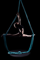 Young woman gymnast with blue gymnastic aerial silks