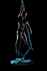 Young woman gymnast with blue gymnastic aerial silks