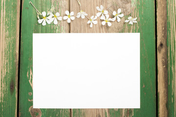 Flowers on vintage wooden planks with blank paper