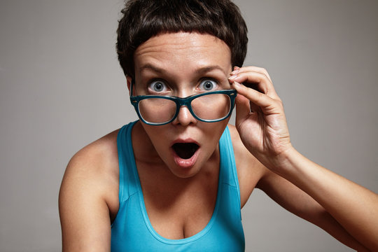 wondering woman watching oover her glasses