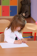 Two-year girl playing and learning in preschool