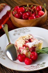 Three cherries in front of pie on white plate