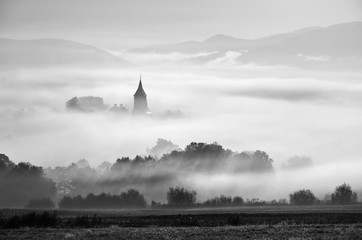 Wierza wiejski kościół w mglistym jesień ranku. - 85456140