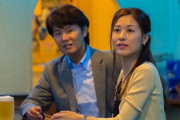 カウンターでお酒を飲むカップル   © Taku