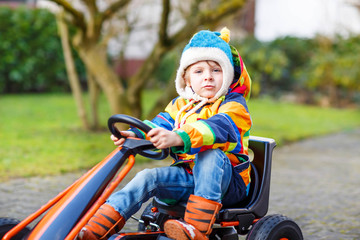 Active cute boy having fun with toy race cars