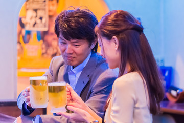 カウンターでお酒を飲むカップル   © Taku