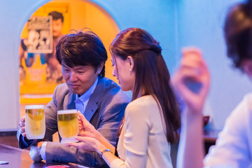 カウンターでお酒を飲むカップル   © Taku