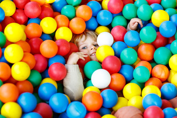 Fototapeta na wymiar child playing at colorful plastic balls playground