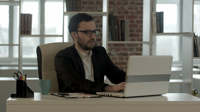 Businessman in funny glasses typing on keyboard has very good
