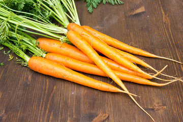 Fresh carrots placed on wooden table close views