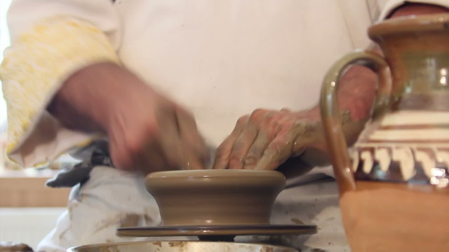 Craftsman shapes pottery on an classic potter's kick wheel