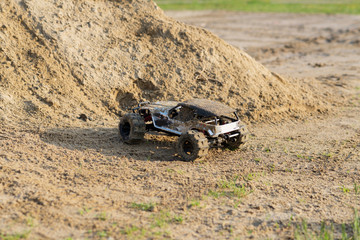 Obraz na płótnie Canvas radio controlled monster truck performing a trick at high speed jumps over a large pile of sand. soft focus and beautiful bokeh