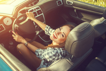 Attractive young woman in a convertible car - obrazy, fototapety, plakaty