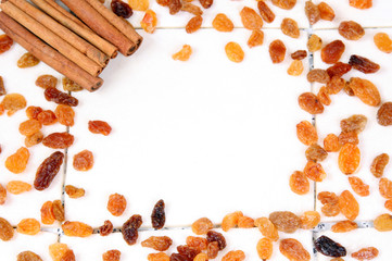 autumn frame of raisins and cinnamon with copy space, background
