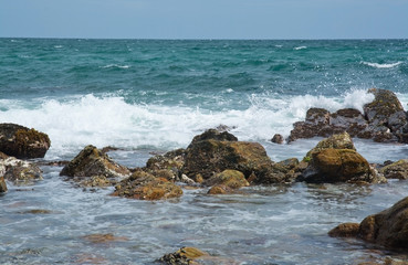 Fototapeta na wymiar Rocky coast landscape with metamorphic rocks and splashing foaming waves, Southern Province, Sri Lanka, Asia.