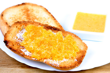 served european breakfast: toasts with butter and orange jam
