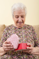 a happy senior woman opening a gift box