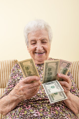senior woman counting money (american dollars)