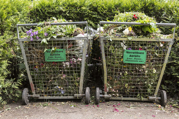 Crates with organic waste on a public cemetery (signs in German for compost)
