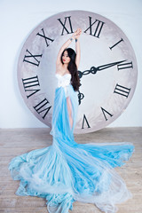 beautiful asian girl in a long dress with plume standing near th