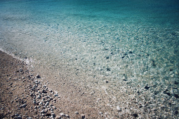 Pebble beach. Blue water. Rocky shore. Southern coast of Turkey.