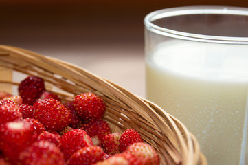 спелая земляника со стаканом молока крупным планом