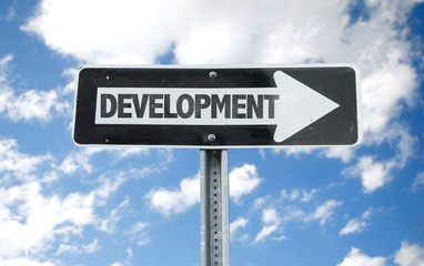 Development direction sign with sky background