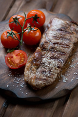 Close-up of striploin beef steak with grilled tomatoes and salt