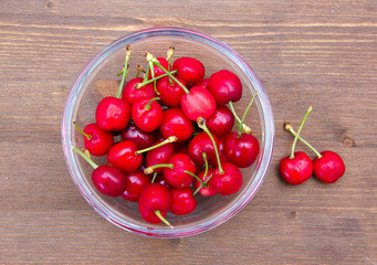 Bowl of cherries on a wooden table top views