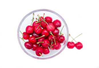 Cherries on bowl on a white background seen from above