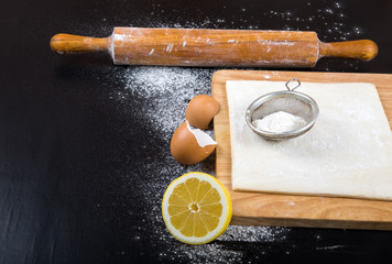 Set for home baking on a black background with flour. Rolling pi