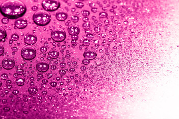 Drops of water on a color background. Pink. Shallow depth of fie