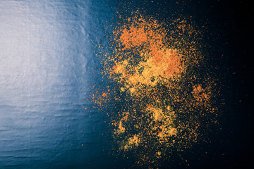 Red and yellow spices on a black background. Selective focus. Cu