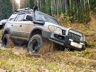 Fototapeta na wymiar Autumn thaw. Jeep got stuck in the woods
