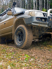 Fototapeta na wymiar Off-road vehicle with a broken bumper stuck in a swamp. Ural