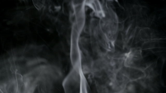 Smoke slow floating in space against black background. 4K UHD.